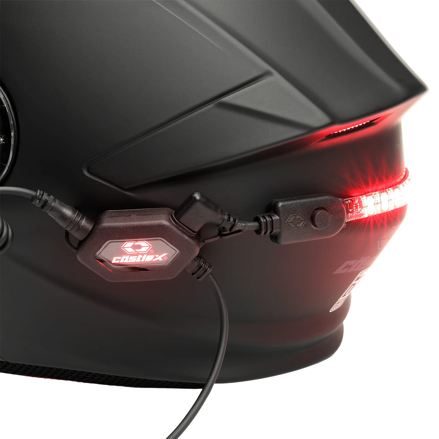 Close-up of a matte black motorcycle helmet with the Illuminator V2 LED Helmet Light Kit installed, showing a red LED light strip and connected wiring on the back, with the CIGTEX brand logo visible on the control unit.